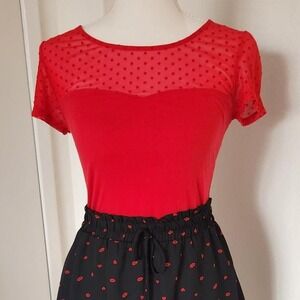 Red short sleeve top with polka dot design and see-through feature